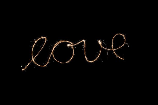 长曝光镜头的火花字“爱”写和孤立在黑色空背景图片下载