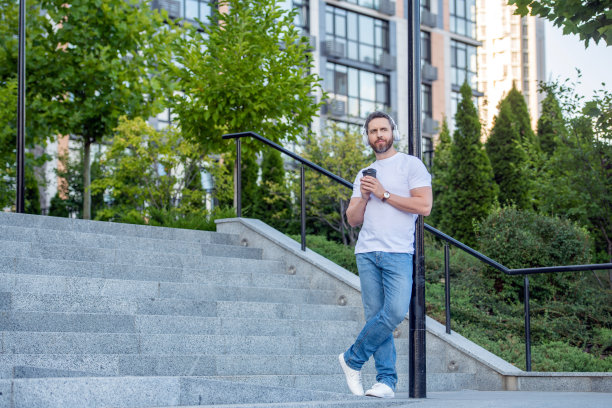 男人戴着耳机听音乐。咖啡休息时间，男人戴着耳机听音乐。图片下载