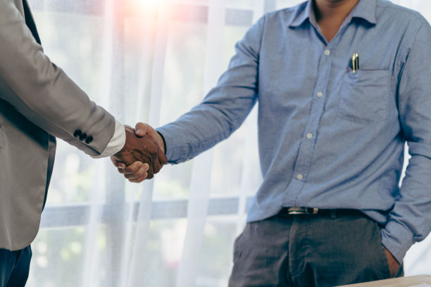 成功的谈判和握手概念两名商人与合作伙伴握手，庆祝合作和团队合作，兼并和收购。成功的谈判，商业交易的概念图片下载