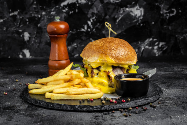 自制汉堡，烤肉，蔬菜，酱汁在乡村的黑色背景。快餐和垃圾食品的概念图片下载