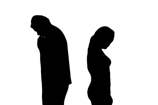 悲伤的男人和女人在争吵的剪影，孤立在白色的背景上。丈夫和妻子在家里客厅的傍晚灯光下离婚图片下载