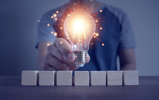 男子在空木块上举着灯泡图片下载