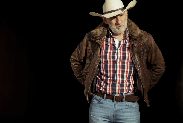 成年男子的肖像在牛仔帽对黑色背景图片下载