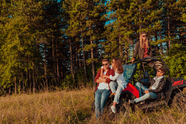 一群快乐的年轻人开着越野车在山间大自然中享受美丽的阳光图片下载