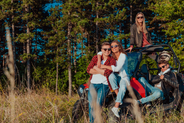 一群快乐的年轻人开着越野车在山间大自然中享受美丽的阳光图片下载