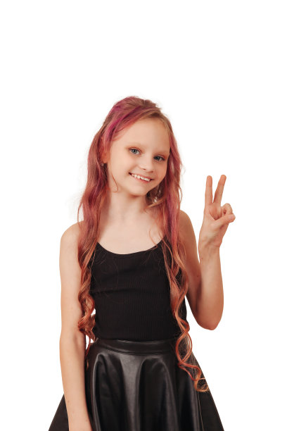 工作室拍摄的小女孩模特与红色长发显示和平标志孤立的空白色背景，看着相机。正面女孩摆姿势拍摄。儿童情感概念。复制广告的文本空间图片下载