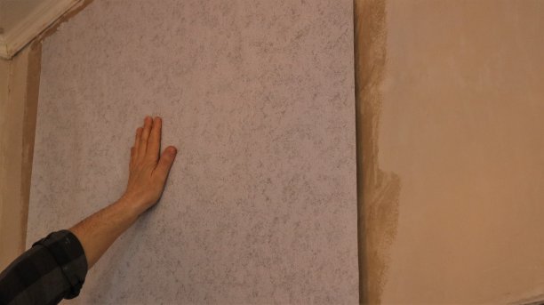 用一只手抚平墙上的墙纸图片下载