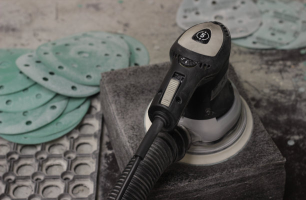 抛光机在工作空间特写。磨圆机用于抛光特写。工作场所有一个用于抛光车身和抛光车轮的电动工具。图片下载