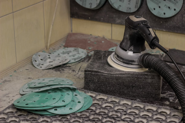 抛光机在工作空间特写。磨圆机用于抛光特写。工作场所有一个用于抛光车身和抛光车轮的电动工具。图片下载
