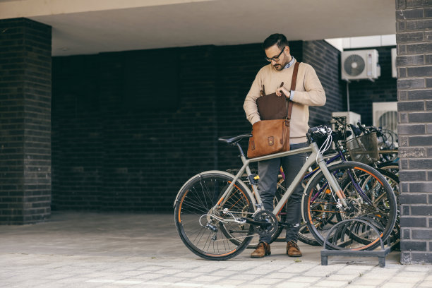 一位城市商人正准备骑自行车去上班。图片下载