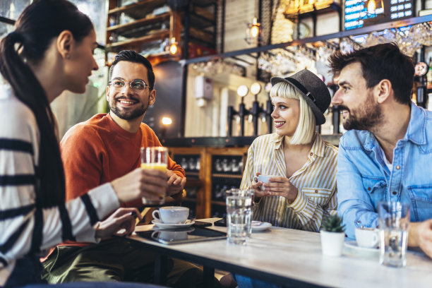 年轻人在咖啡馆里玩得很开心。朋友们坐在咖啡店里，一起喝咖啡，玩得很开心。图片下载