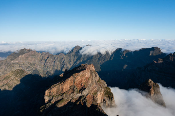 Epic mountain scenery on the small island of Madeira with a large sea of ​​clouds behind the mountain peaks.图片下载