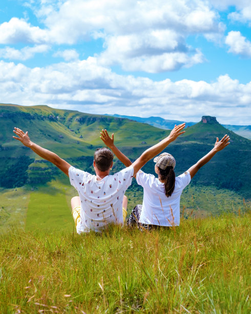 在南非德拉肯斯堡巨人城堡的山上，一对男女高举双手图片下载