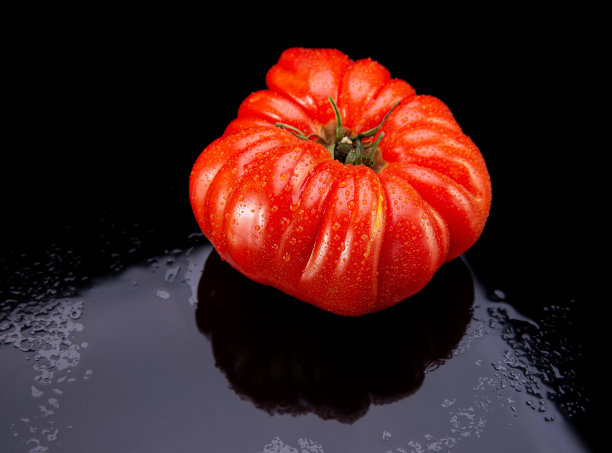传家宝番茄在黑色湿玻璃与反射图片下载