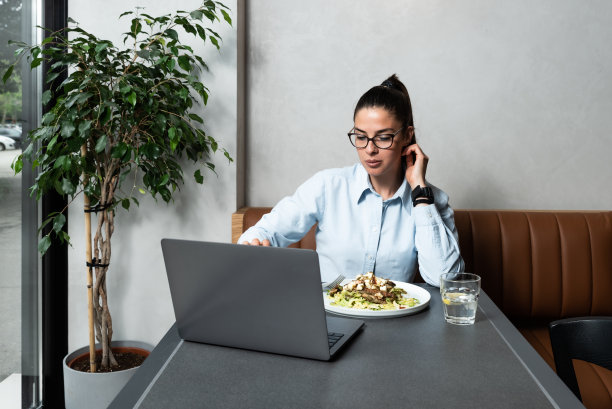 年轻的成功快乐的商业女性在午休时间抓住机会和她在另一家公司工作的男朋友进行视频通话。网上约会，网上调情图片下载