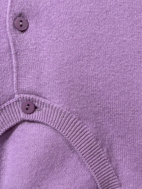 纹理背景的紫色针织羊毛针织服装与纽扣。图片下载