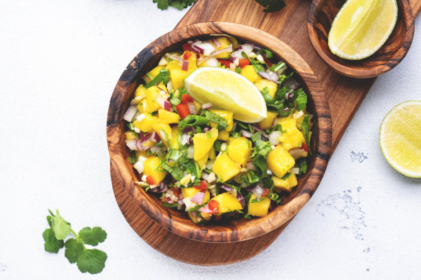 辣味芒果沙司配红辣椒、洋葱、大蒜、青柠和香菜，白色桌面背景，俯视图图片下载