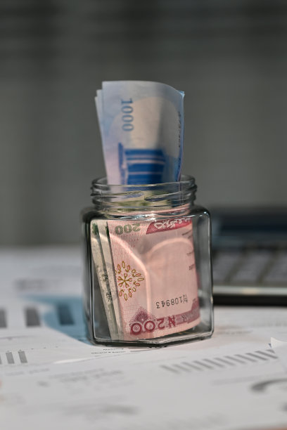 一个透明的玻璃罐装满奈拉钞票和计算器图片下载