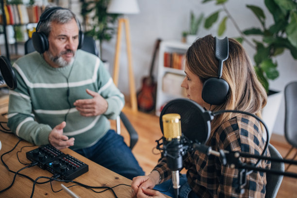 一位电台主持人在演播室里和一位老人谈话图片下载