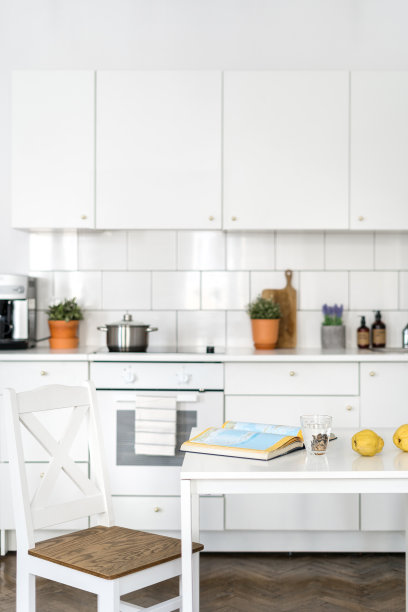 木椅靠近桌子，打开的书和玻璃在舒适的厨房图片下载