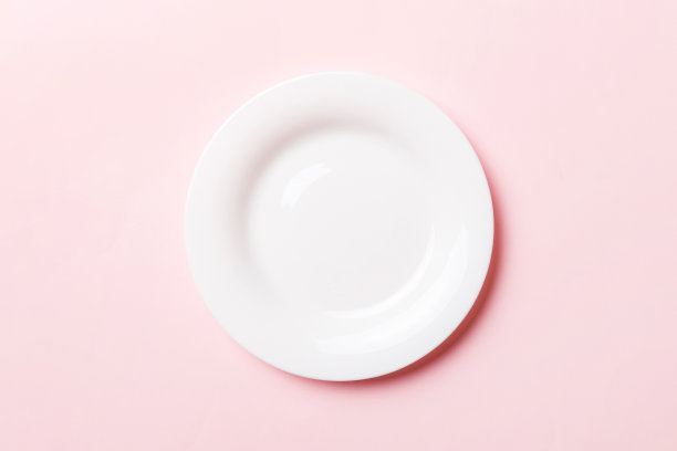 顶视图隔离的彩色背景空圆形的白色盘子的食物。为你的设计腾出空间图片下载