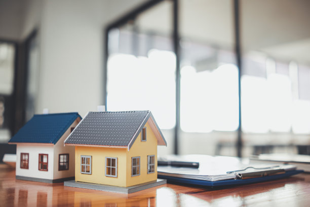 房地产销售办公室的桌子上摆放着房地产销售文件和样板房，以便潜在买家与经销商签订房地产销售合同。图片下载