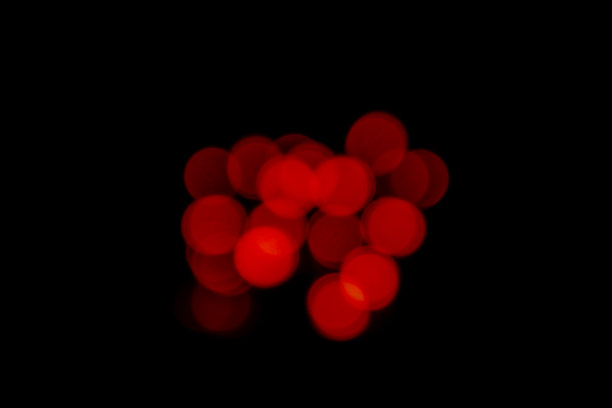 黑色背景上的红色模糊散景灯图片下载