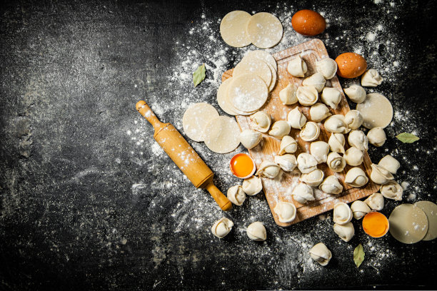 生饺子配上鸡蛋、擀面杖和面粉。图片下载