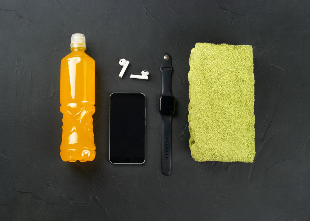 健身和跑步的概念。毛巾，橙色等渗瓶，智能手机，耳机和智能手表，俯视图图片下载