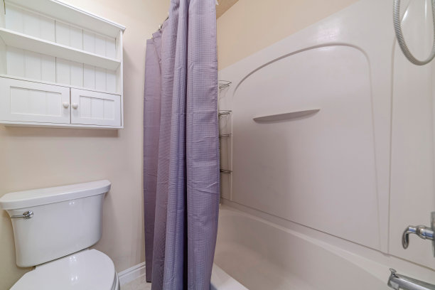 浴室马桶座旁有窗帘的小浴缸图片下载