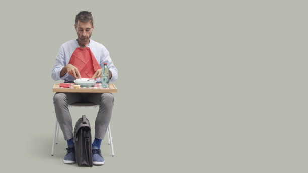 一个人坐在椅子上吃午饭图片下载