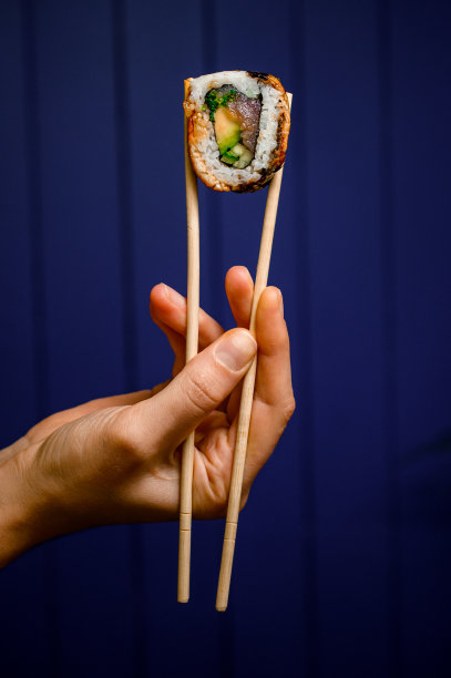 侧面的一个美味的费城卷握着木筷子图片下载