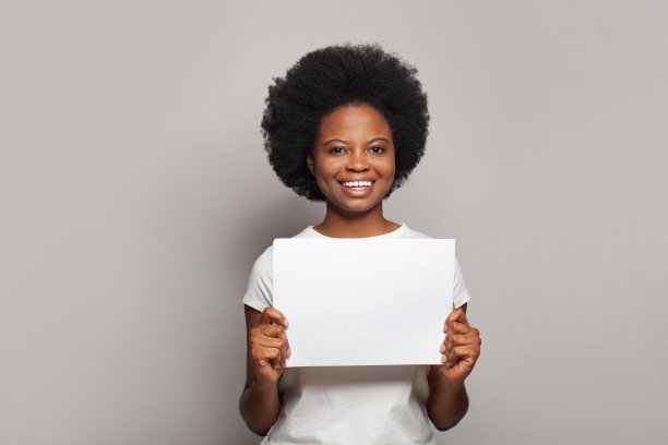 自信的女人微笑着，在白色的背景上展示白色的空纸横幅图片下载