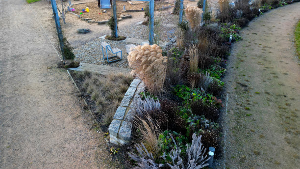 从金属结构到攀爬植物和藤蔓，是一个由粗糙的石头铺装的立方体组成的露台。金属灰色的家具，长凳，椅子，咖啡。观点，公园常年公共图片下载