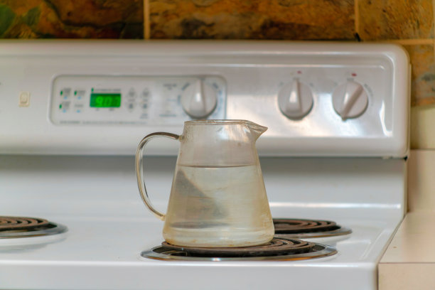 厨房里放在炉子上烧水的玻璃茶壶图片下载