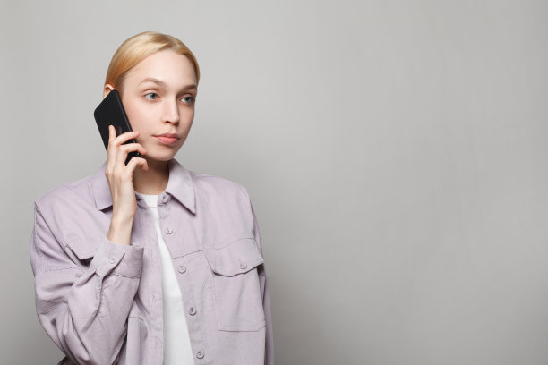 聪明的女学生拿着智能手机在白色的工作室墙上横幅背景图片下载