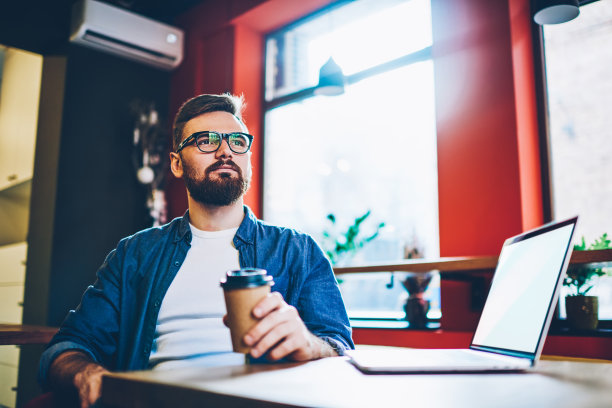 深思熟虑的商人，便装咖啡和空白屏幕笔记本电脑在咖啡馆图片下载