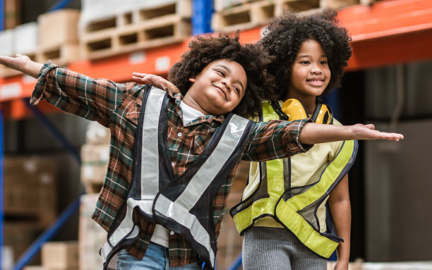 两个非洲小男孩、小女孩站在仓库里，梦想成为建筑师、工程师、工人或企业主，带着复制空间的快乐微笑和欢笑。教育、职业理念。图片下载