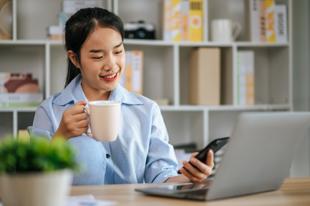 年轻女子在家里用笔记本电脑和智能手机工作图片下载