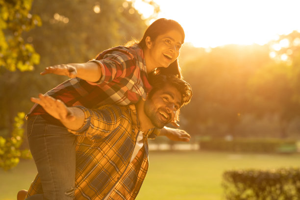 年轻夫妇在公园玩得很开心。库存图片图片下载