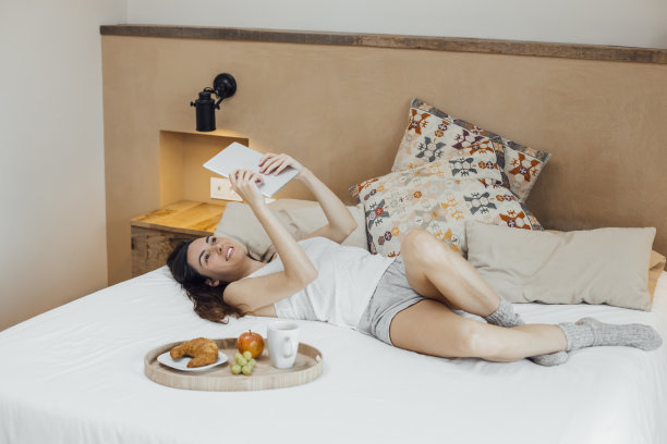 女人早餐在床上冷却和使用平板电脑图片下载