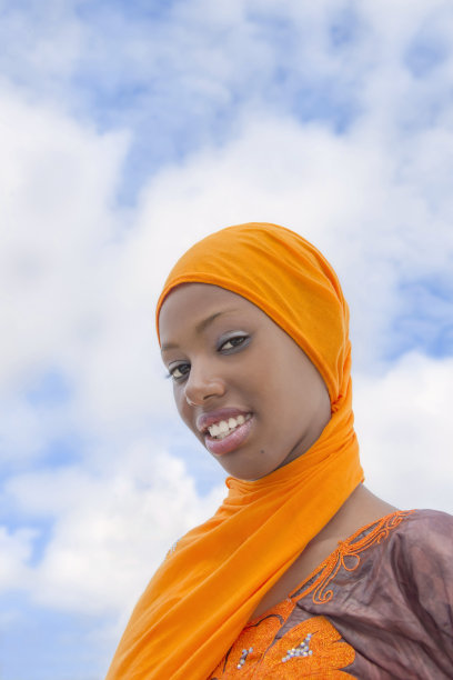 漂亮女孩(18岁)，头戴传统头巾，身穿刺绣连衣裙，橘色，户外，蓝天，云景，照片，横式图片下载