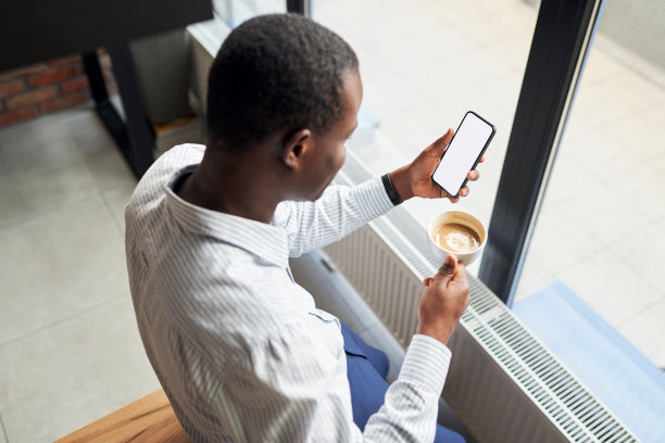 照片中无法识别的商人在办公室拿着空白模板屏幕的智能手机图片下载