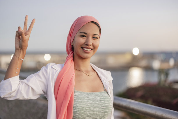 与癌症作斗争的亚洲女性，戴着粉色围巾图片下载