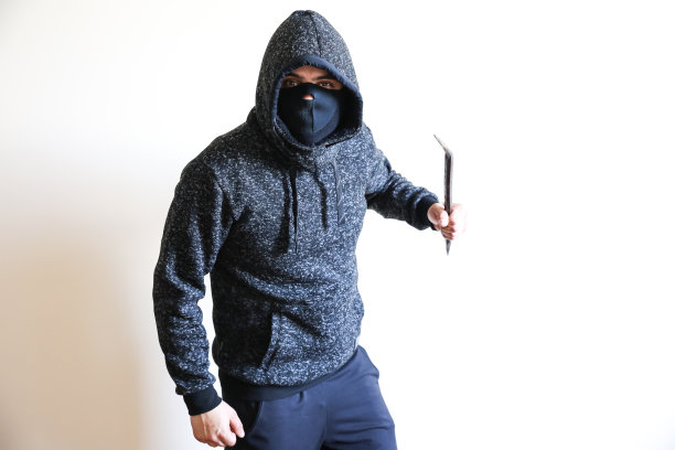 门附近有拿着撬棍的罪犯。穿黑色连帽衫的强盗。图片下载