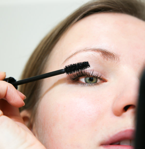 女孩正在化妆。黑色睫毛膏在睫毛上。美丽的照片概念。图片下载