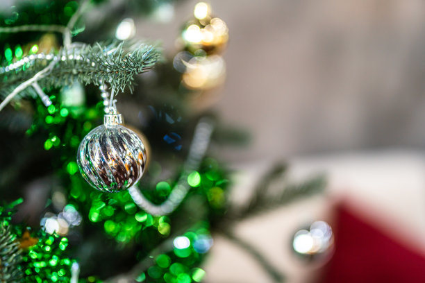 圣诞快乐，近距离彩色球，礼品盒和圣诞祝福图片包裹装饰在绿色圣诞树背景装饰在圣诞节和新年。图片下载