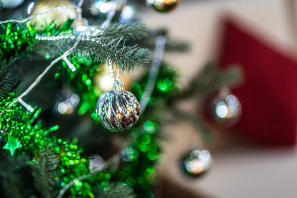 圣诞快乐，近距离彩色球，礼品盒和圣诞祝福图片包裹装饰在绿色圣诞树背景装饰在圣诞节和新年。图片下载