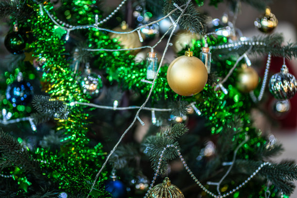 圣诞快乐，近距离彩色球，礼品盒和圣诞祝福图片包裹装饰在绿色圣诞树背景装饰在圣诞节和新年。图片下载