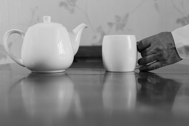 白色陶瓷茶壶和白色陶瓷马克杯在一个老人的手中图片下载